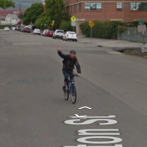 Google-StreetView image of Lasse Scherfig on a bike. Near the bottom, a fragment of the street name can be seen, spelling "ton St".